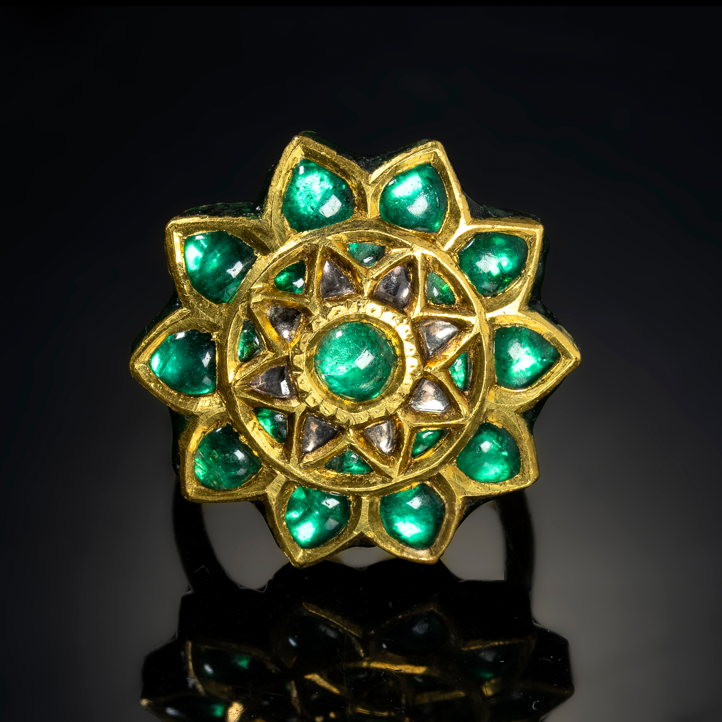 A 20th century Indian gold and enamel ring with foiled emeralds. 